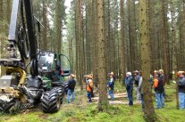Mehrere Personen vor einem Harvester im Wald