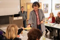 Workshopteilnehmerin übergibt Zettel an Referentin Zeller